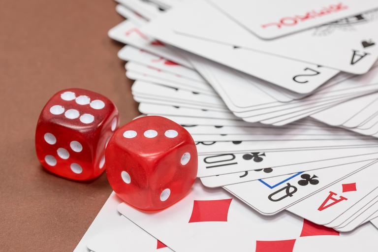 Red dice near playing cards. 